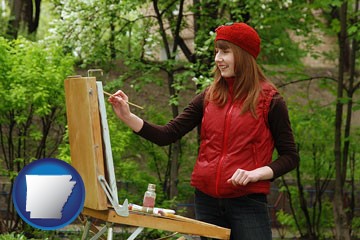 a female plein air artist painting with oils on a portable easel - with Arkansas icon