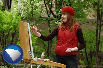a female plein air artist painting with oils on a portable easel - with South Carolina icon